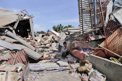 Un niño junto a los escombros de unos edificios tras el terremoto en Pidie Jaya (Indonesia).