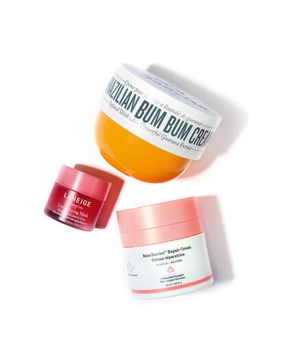 De arriba abajo, tres favoritos de los alfa: hidratante corporal Brazilian Bum Bum Cream de SOL DE JANEIRO, mascarilla nocturna para labios de LANEIGE y crema facial reparadora Bora Barrier de DRUNK ELEPHANT.