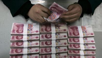 Un empleado del Bank of China cuenta billetes de 100 yuanes en Taiyuan, provincia de Shanxi.