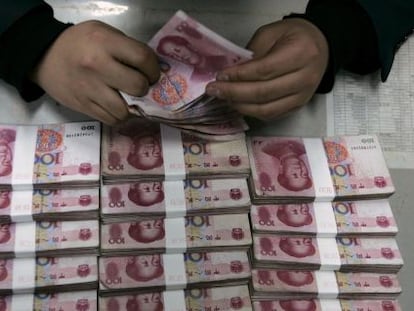 Un empleado del Bank of China cuenta billetes de 100 yuanes en Taiyuan, provincia de Shanxi.