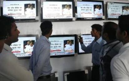 Varias personas siguen hoy por televisión el discurso del ministro de Finanzas indio, P. Chidambaram en una tienda de electrónica en Bhopal (India).