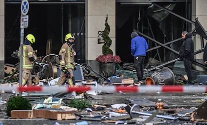 Bomberos entre los escombros a la entrada del hotel.
