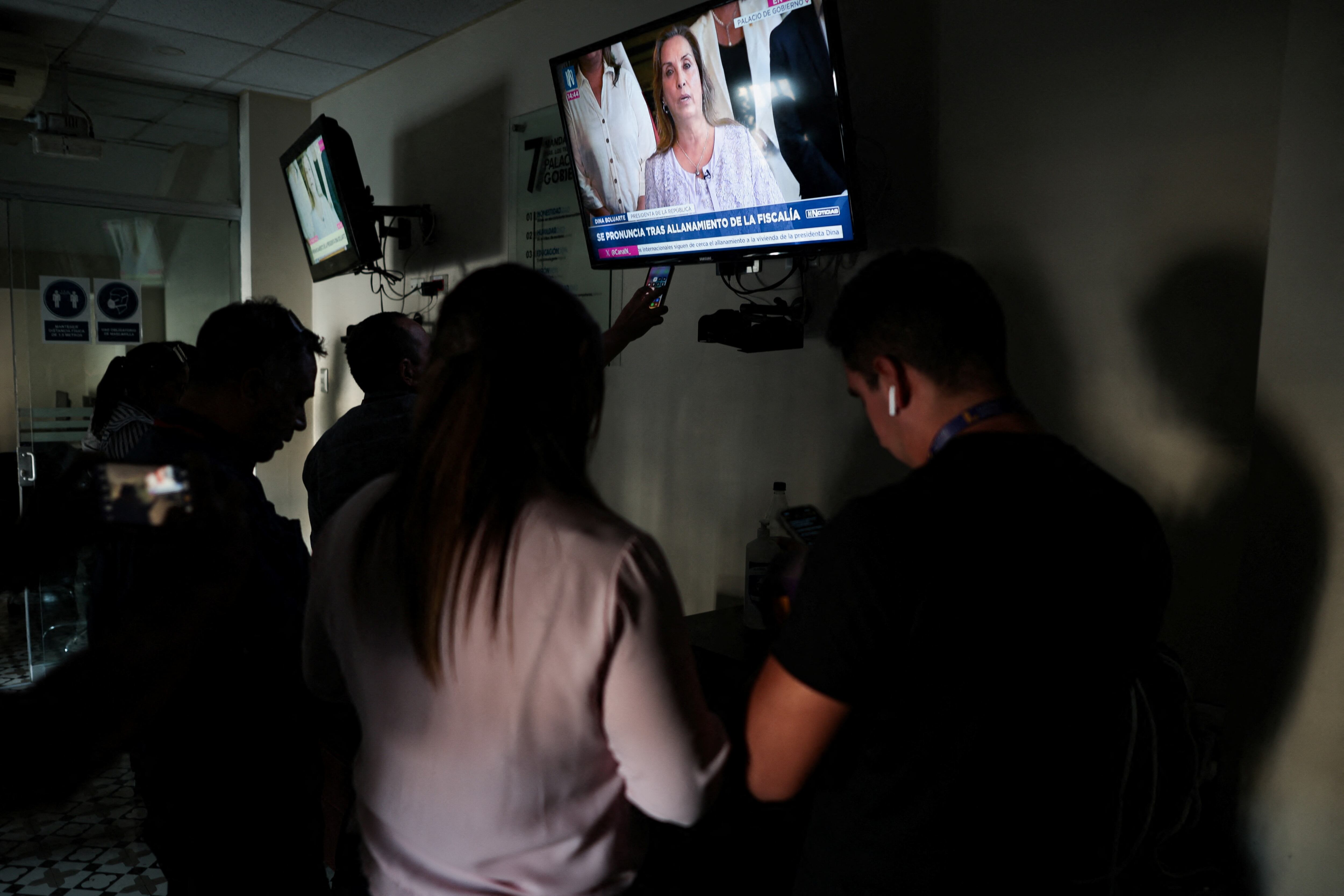 Ciudadanos observan el discurso televisado, este 30 de marzo en Lima.