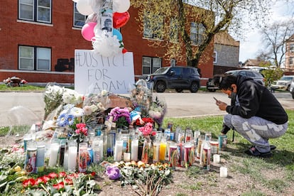 Una mujer se arrodilla frente a un altar en memoria de Adam Toledo, de 13 años, instalado cerca del callejón donde un policía le disparó en el vecindario de La Villita en Chicago.