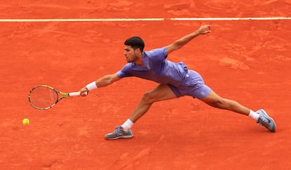 Alcaraz alarga el brazo para llegar a la pelota.