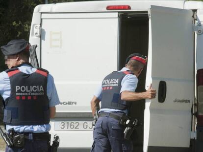 Dos agentes de los Mossos D&acute;Esquadra inspeccionan el interior de una furgoneta en carretra C-17 a su paso por Ripoll.