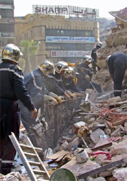 Un grupo de bomberos busca supervivientes entre los escombros.