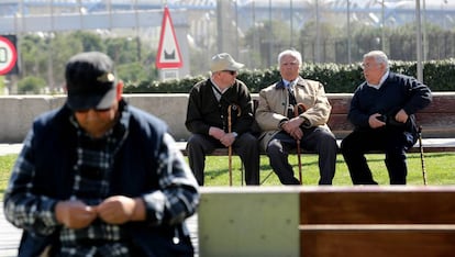 Varios ancianos sentados en un banco del parque lineal Madrid Río. 