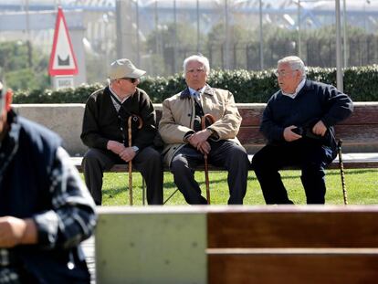Varios ancianos sentados en un banco del parque lineal Madrid Río. 
