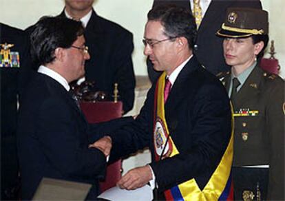 Uribe (d.) saluda a su vicepresidente, Francisco Santos, tras ser investido presidente.