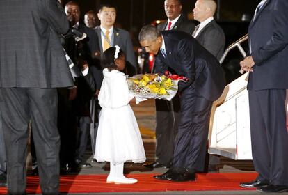 Una niña le entrega un ramo de flores a Barack Obama a su llegada al aeropuerto internacional de Nairobi.