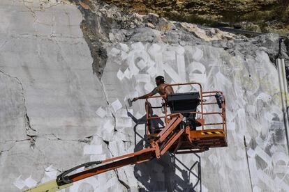 El artista francés del graffiti, Loïc Monde, pinta en una pared de una cantera de piedra caliza.