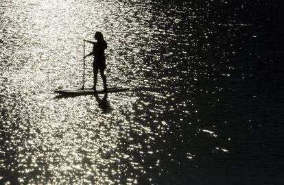 Una mujer disfruta del mar sobre una tabla, en el lago Quannapowitt, en Wakefield, Massachussets (EE.UU).