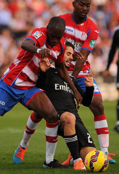 Isco trata de superar a los defensas del Granada Allan Nyom (i) y Dimitri Foulquier (d).