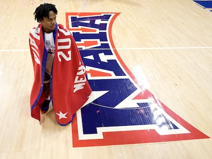 Freed-Hardeman guard Quan Lax wears the championship banner after the NAIA men's national championship college basketball game against Langston, Tuesday, March 26, 2024, in Kansas City, Mo.
