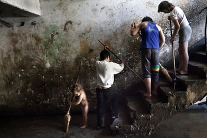 Varios niños gitanos limpian las viviendas sociales donde viven en Rumanía.