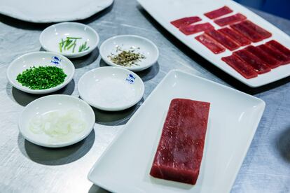 Los ingredientes y el corte concreto del lomo para preparar el usuzukuri de atún encebollado. 