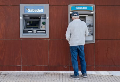 Un cliente del Sabadell saca dinero de un cajero en Alicante.