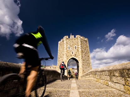 Ciclistas entrando en la villa medieval de Besalú, en la Garrotxa (Girona).