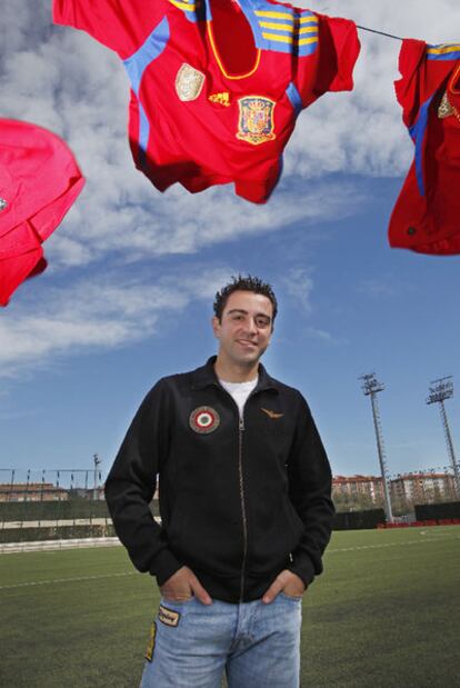 Xavi, en la Ciudad Deportiva del Barça, con varias camisetas que ha utilizado con España.