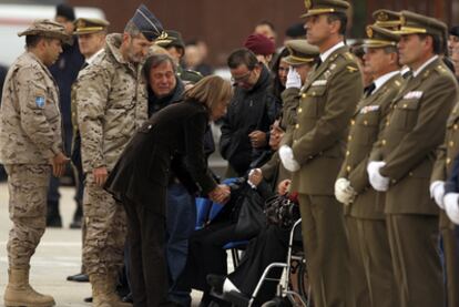 La ministra Carme Chacón da el pésame a la familia del sargento primero Joaquín Moya, entre ellos su viuda, con la mano en el rostro.