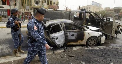 Unos policías inspeccionan el lugar donde explotó una bomba en un doble atentado en la provincia oriental iraquí de Diyala.