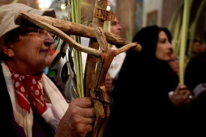 Un peregrino Católica sostiene un crucifijo y una rama de palma durante la procesión del Domingo de Ramos en la Iglesia del Santo Sepulcro en la Ciudad Vieja de Jerusalén.