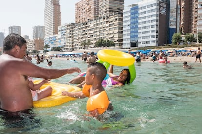 Mario Baltodano (l) plays at the beach in Benidorm with Alexander (c) and Andrea (on the float).