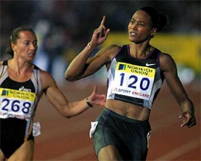 Marion Jones hace un gesto de triunfo ante Pintusevich, que corrió en la calle contigua ayer en Londres.