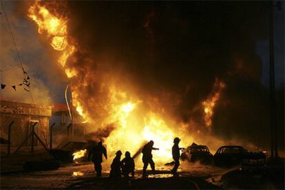 Los bomberos tratan de controlar el fuego en la gasolinera del barrio Al Amin tras el estallido del coche bomba.