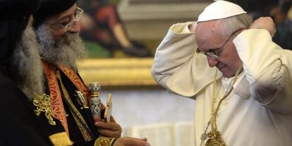 El papa Francisco (d.) se coloca en el cuello un regalo del patriarca de la Iglesia Copta Ortodoxa de Egipto, Teodoro II (i.), este viernes en El Vaticano. 