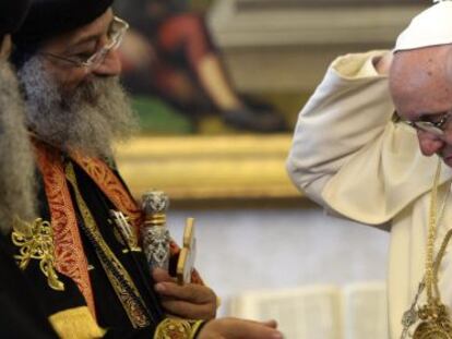 El papa Francisco (d.) se coloca en el cuello un regalo del patriarca de la Iglesia Copta Ortodoxa de Egipto, Teodoro II (i.), este viernes en El Vaticano.