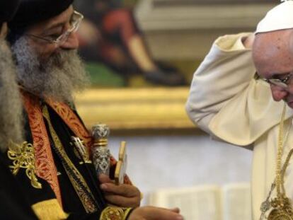 El papa Francisco (d.) se coloca en el cuello un regalo del patriarca de la Iglesia Copta Ortodoxa de Egipto, Teodoro II (i.), este viernes en El Vaticano. 