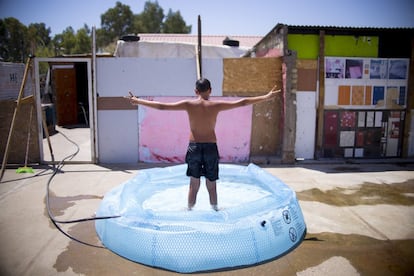 Un niño se baña en una piscina hinchable, en el asentamiento chabolista de El Vacie, en Sevilla.
