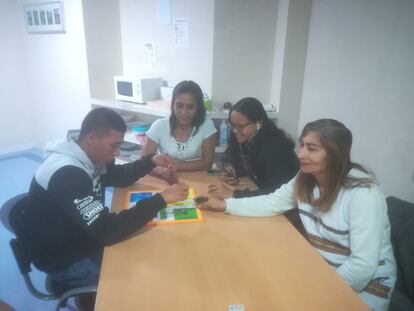 Cuatro de los refugiados, jugando al parchís en el salón.