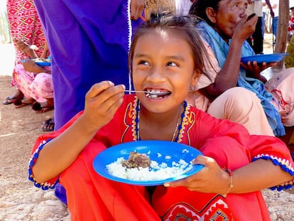 Una niña come arroz con chivo en la comunidad indígena wayúu del Guayabal, en Colombia.