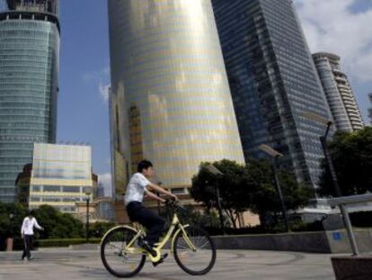 Un ciclista da un paseo por las calles del distrito financiero de Pudong, Shanghai (China).