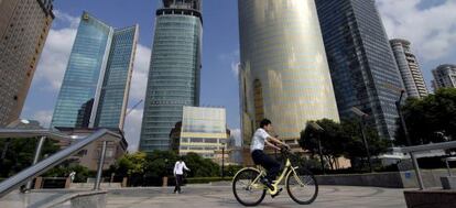 Un ciclista da un paseo por las calles del distrito financiero de Pudong, Shanghai (China).