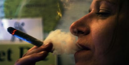 Una mujer fuma un cigarro de cannabis en un &#039;coffeeshop&#039; de &Aacute;msterdam.
