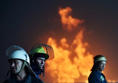 Varios bomberos participan en las labores de extinción del incendio de un depósito de combustible en el pueblo de Kryachki, al suroeste de Kiev. Ucrania.