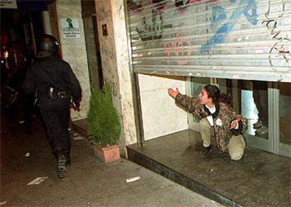 Una manifestante refugiada en un local público increpa a los policías durante una carga en el centro de Madrid.