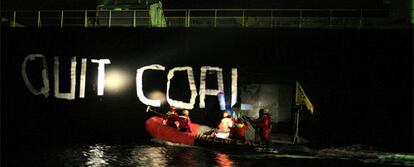 Miembros de Greenpeace pintan el lema 'Abandonemos el carbón' en un barco carbonero en Gijón