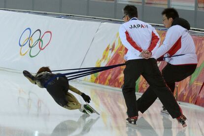 El personal del equipo japonés ayuda a un patinador durante su sesión de entrenamiento. 