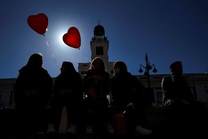 Unas jóvenes sostienen globos con forma de corazón en la Puerta del Sol en Madrid, este lunes.