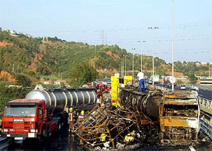 A la derecha, el camión que transportaba 30.000 litros de disolvente, que no llegaron a verterse a pesar de que el resto del vehículo quedó abrasado.