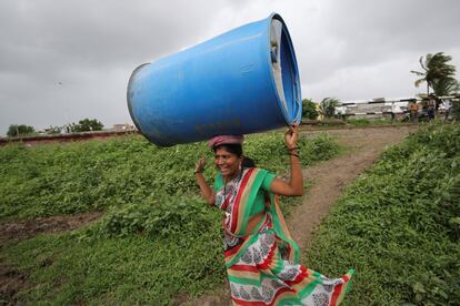 Una mujer lleva un contenedor de plástico en Aurangabad (India).