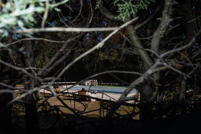 
Una piscina en el interior de una finca vista desde la calle. 
