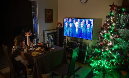 A family watches Vladimir Putin's New Year speech on television on December 31 in Moscow.
