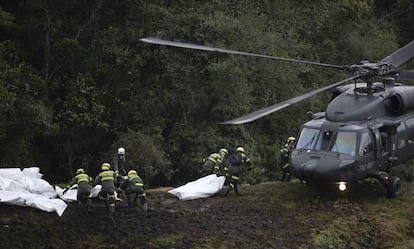 Un equipo de rescate introduce varios cuerpos de las víctimas en un helicóptero.