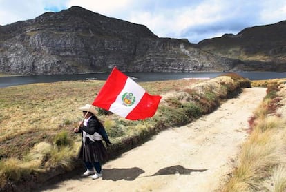 Una campesina ondea una bandera de Perú hoy, miércoles 18 de julio de 2012, en la laguna Namucocha, en Cajamarca (Peru).